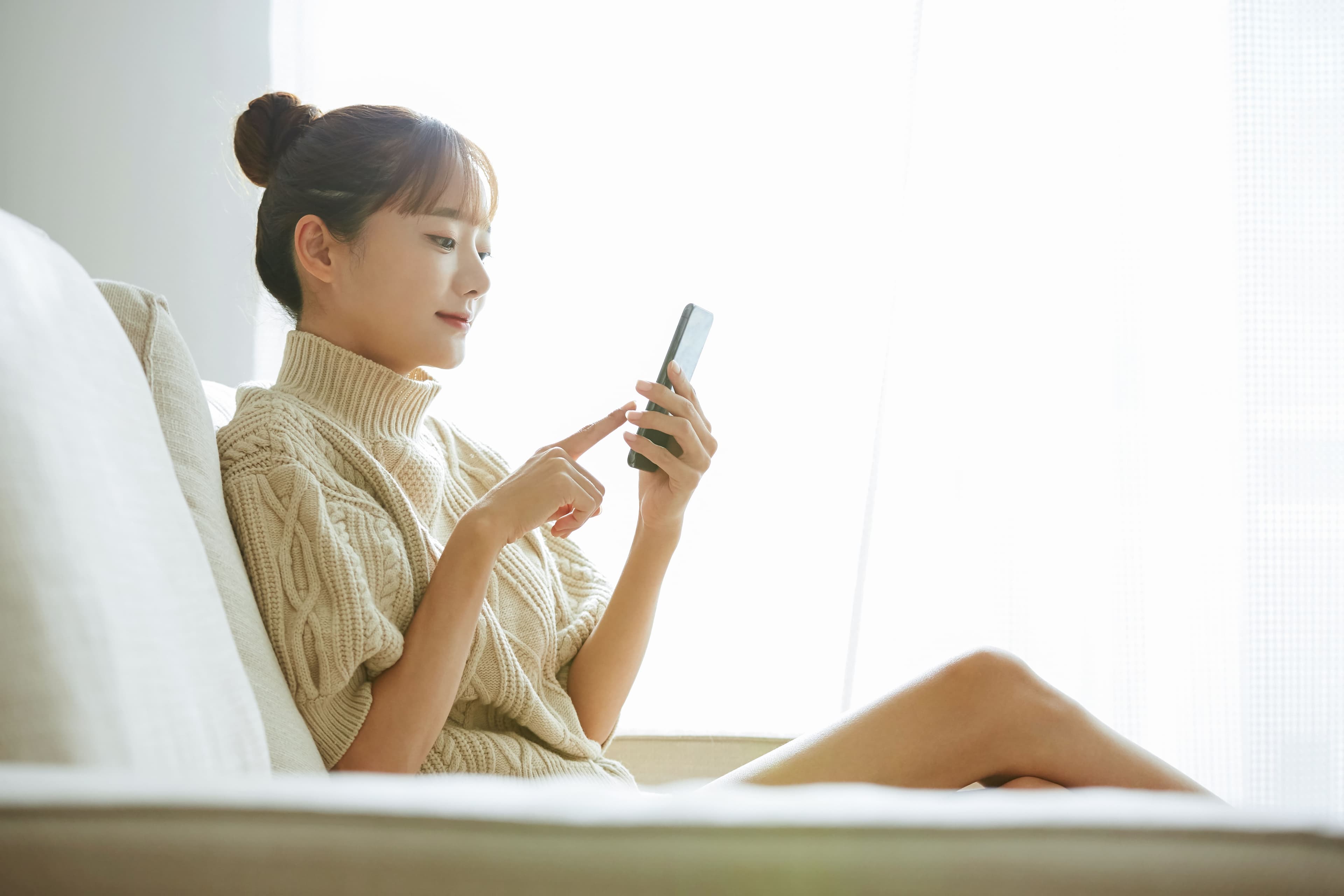 自宅のソファでスマートフォンから事前カウンセリング