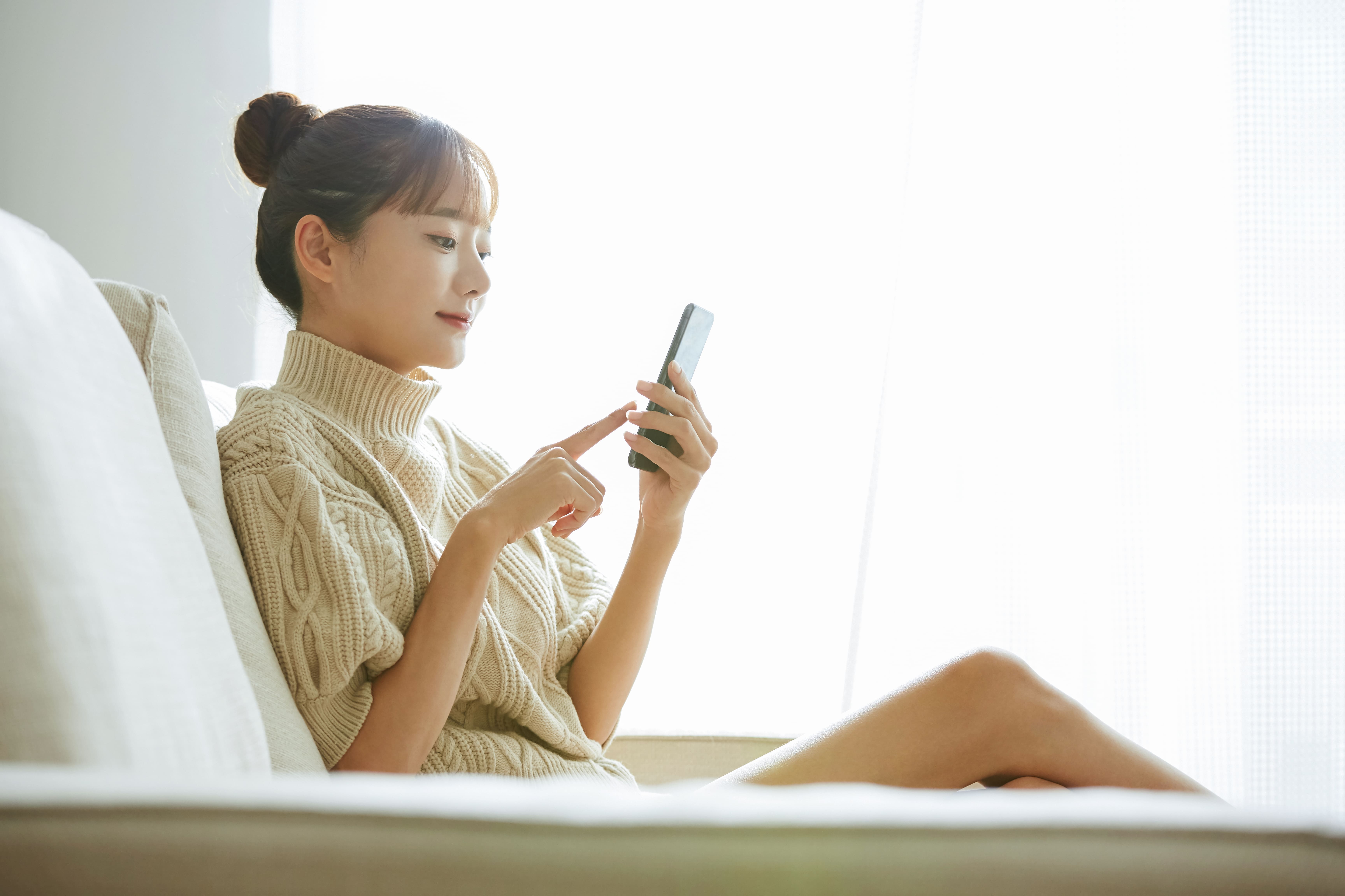 自宅のソファでスマートフォンから事前カウンセリング